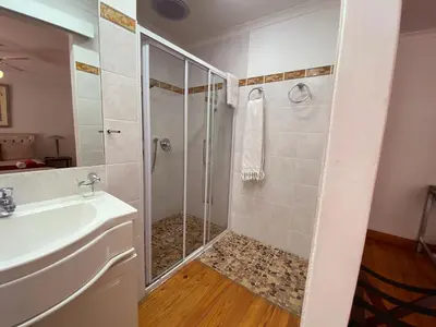 a bathroom with a shower and a sink at Le Bay Lodge in Gordonʼs Bay