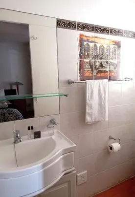 a bathroom with a sink and a mirror at Le Bay Lodge in Gordonʼs Bay