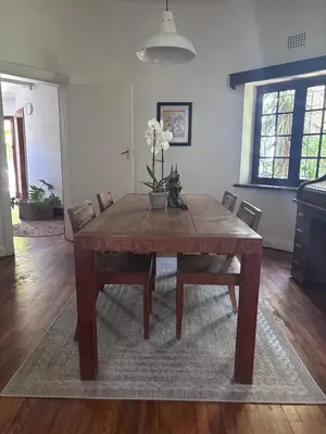 a dining room table with chairs and flowers on it at Catlovers Corner in Paarl