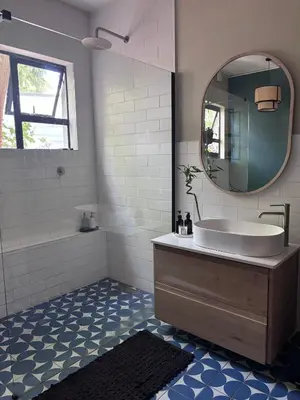 a bathroom with a tub and a sink and a mirror at Catlovers Corner in Paarl