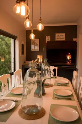 a dining room table with two glass vases on it at CalTye On Sea in Hermanus