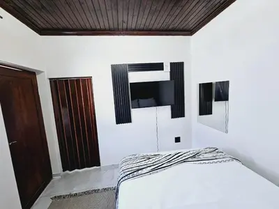 a bedroom with a bed and a television on the wall at Evernice Guest House in Cape Town