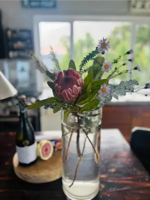 a vase with flowers in it on a table at Fynbos Mountain View in Kleinmond