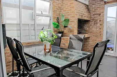 a dining room with a glass table and chairs at Sukoluhle Guest House in Cape Town