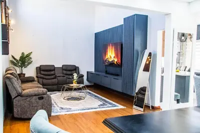 a living room with a fireplace in the wall at Sukoluhle Guest House in Cape Town