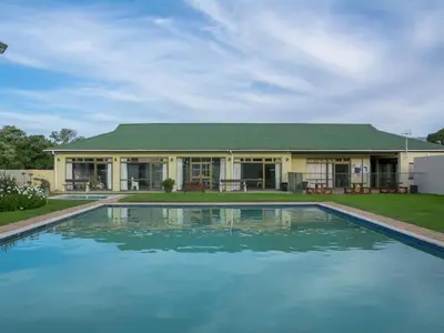 a house with a swimming pool in front of a house at Die Steenbras in Fisherhaven