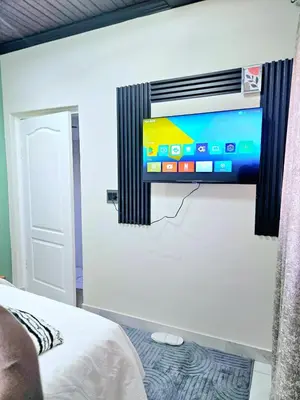 a flat screen tv on a wall in a bedroom at Evernice Guest House in Cape Town
