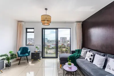 a living room with a couch and a large window at Knightsbridge 702W by CTHA in Cape Town