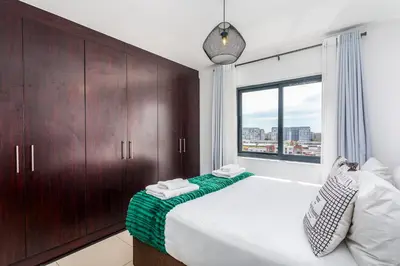 a bedroom with a large bed and a window at Knightsbridge 702W by CTHA in Cape Town