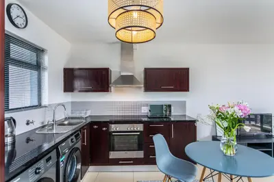 a kitchen with a table and a vase of flowers at Knightsbridge 702W by CTHA in Cape Town