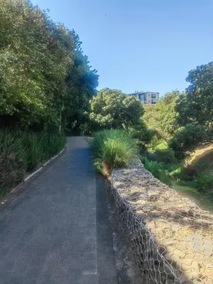 a fence next to a walkway next to a road at Classy Budget Apartment in Tyger Valley