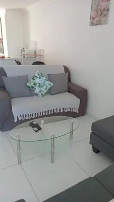 a living room with a couch and a glass table at Classy Budget Apartment in Tyger Valley