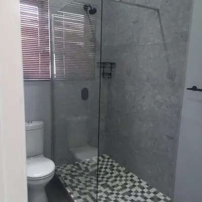 a bathroom with a glass shower with a toilet at Forbes on Zastron in Cape Town