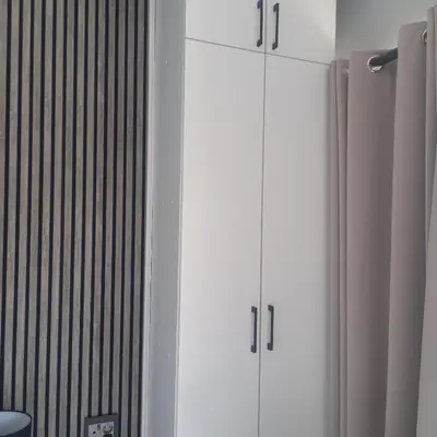 two white cabinets sitting next to a wall at Forbes on Zastron in Cape Town