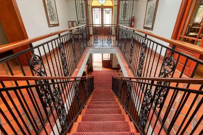 a staircase in a building with wooden railings at Berg en Zee Guesthouse in Gordonʼs Bay