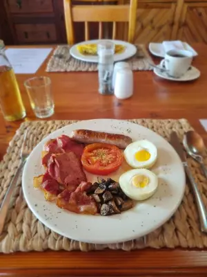 a plate of breakfast food on a table at Berg en Zee Guesthouse in Gordonʼs Bay