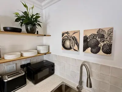 a kitchen with a sink and a microwave at The Sultan Cottage in Stellenbosch