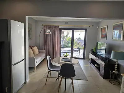 a living room with a couch and a table at Induli on Sage in Plattekloof