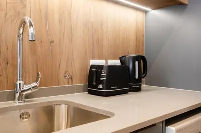 a kitchen counter with a coffee maker and a sink at 721 Riverlands - Lux 2 Bedroom Apartment in Cape Town