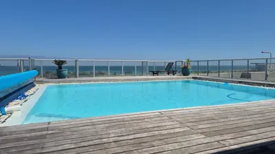 a swimming pool with a view of the ocean at Seaspray Apartment Blauberg in Cape Town