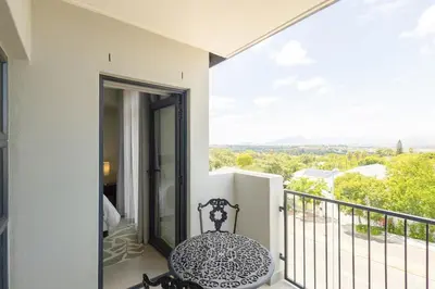 a balcony with a chair and a view at Durbanville Daydream in Durbanville