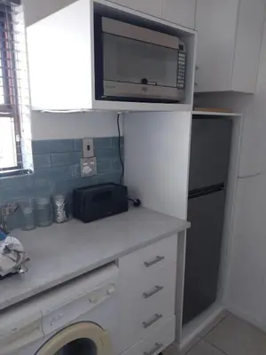 a kitchen with a counter with a microwave and a sink at Catch And Release Hermanus in Hermanus