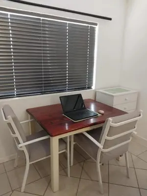 a laptop computer sitting on a wooden desk with two chairs at Catch And Release Hermanus in Hermanus