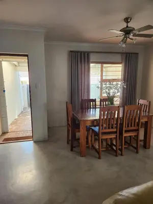 a dining room with a wooden table and chairs at Home in Somerset Ridge in Somerset West