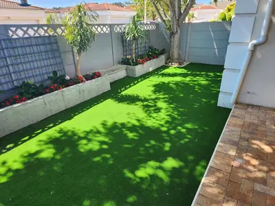 a yard with a green lawn with a fence and trees at Home in Somerset Ridge in Somerset West