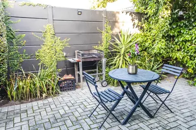 a patio with a table and two chairs and a grill at Seagull Apartment Hermanus in Hermanus