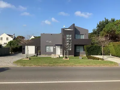 a black house on the side of a road at Seagull Apartment Hermanus in Hermanus