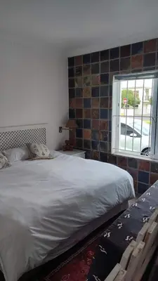 a bedroom with a large bed and a window at Zoute Zoene in Kleinmond