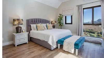 a bedroom with a large bed and a window at Château Famille in Franschhoek