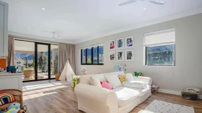 a living room with a white couch and some windows at Château Famille in Franschhoek