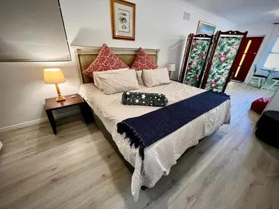 a bed in a room with a lamp and a table at Ebgow Cottage in Cape Town