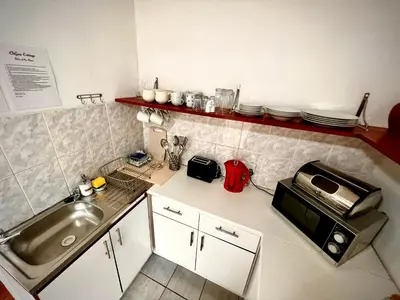 a small kitchen with a sink and a microwave at Ebgow Cottage in Cape Town