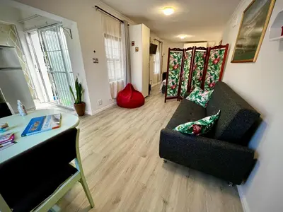 a living room with a couch and a table at Ebgow Cottage in Cape Town
