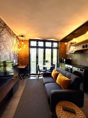 a living room with a couch and a table at CAG Bosman's Crossing Stellenbosch in Stellenbosch