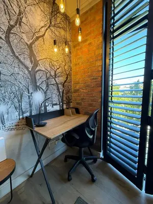 an office with a desk and a chair in front of a brick wall at CAG Bosman's Crossing Stellenbosch in Stellenbosch