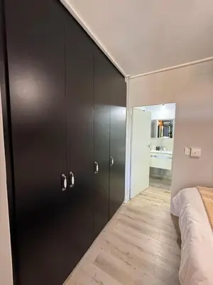 a bedroom with black cabinets and a bed in it at CAG Bosman's Crossing Stellenbosch in Stellenbosch