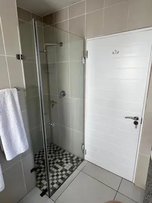 a shower with a glass door in a bathroom at Vermont Hermanus Flatlet in Hermanus