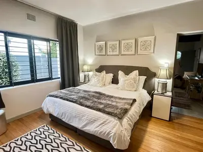 a bedroom with a large bed with white sheets and pillows at Stay on Main 2 in Paarl