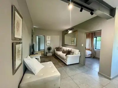 a living room with a couch and a table at Stay on Main 2 in Paarl