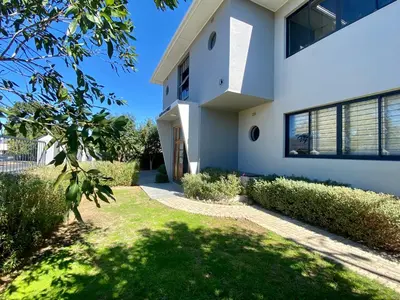 a white house with a green yard at Stay on Main 2 in Paarl