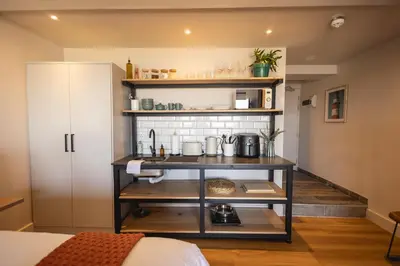 a room with a kitchen with a counter and shelves at Oceanfront Duplex Apartments, Hermanus Waterfront in Hermanus