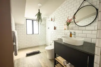 a white bathroom with a sink and a mirror at Oceanfront Duplex Apartments, Hermanus Waterfront in Hermanus