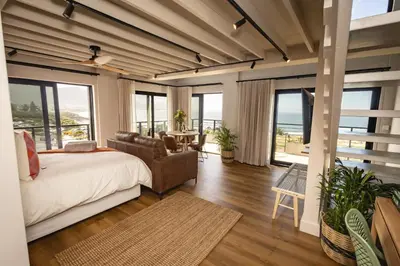 a bedroom with a bed and a view of the ocean at Oceanfront Duplex Apartments, Hermanus Waterfront in Hermanus