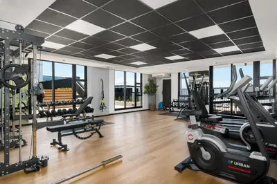 a gym with treadmills and elliptical machines at Sunbird Apartments in Cape Town