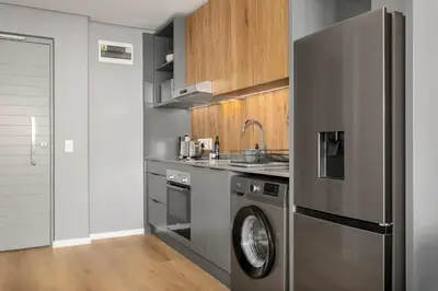 a kitchen with a stainless steel refrigerator and a dishwasher at Sunbird Apartments in Cape Town