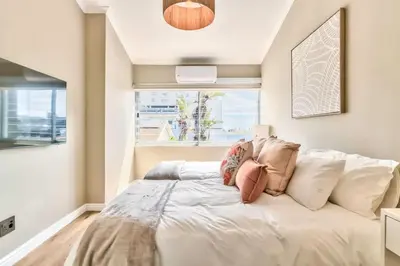 a large white bed in a room with a window at Silverview Modern Duplex Fully Air-Conditioned near Beach in Cape Town